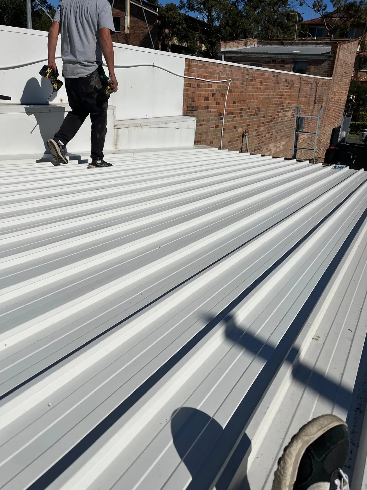 Roofer walking a large-span commercial metal roof