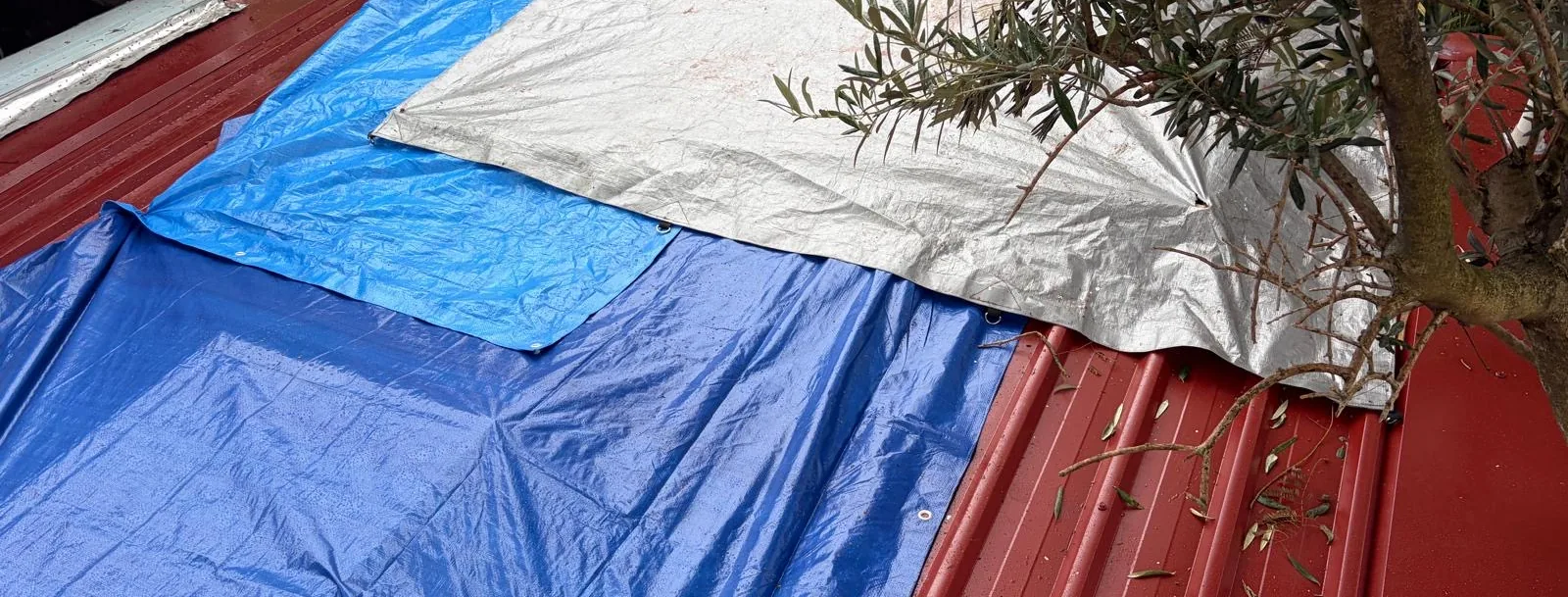 Tarpaulins covering an exposed roof during emergency works