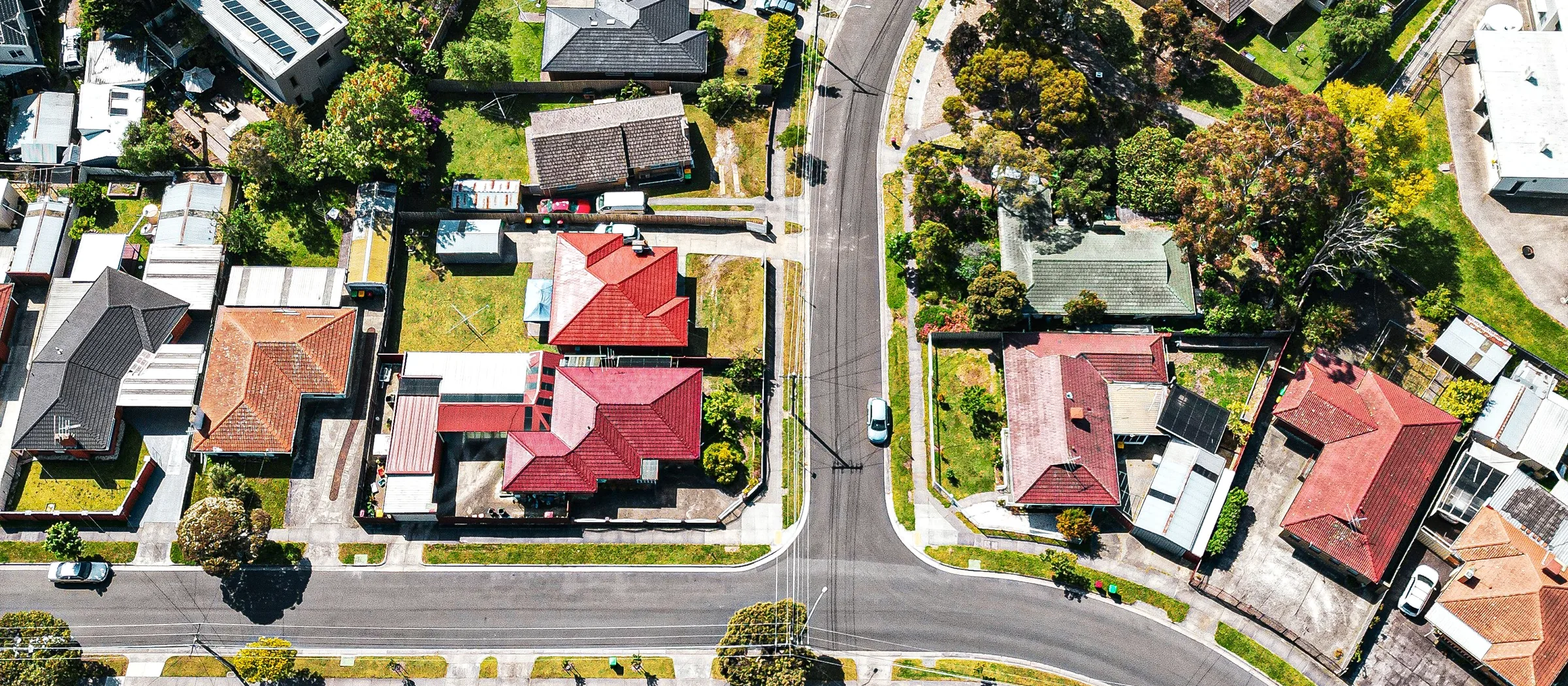 Aerial view of densely built suburban rooftops and low-rise flat blocks