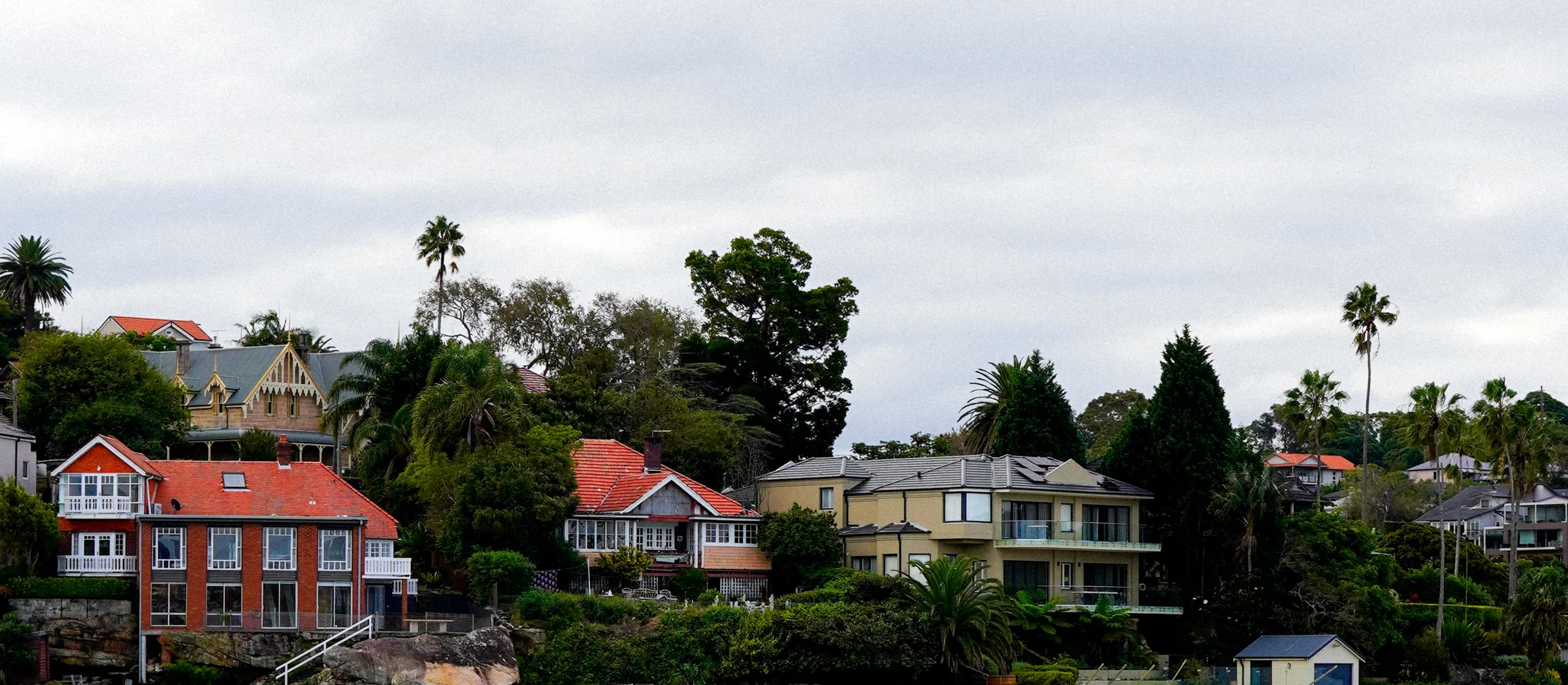 Waterfront houses with tiled roofs seen across the water