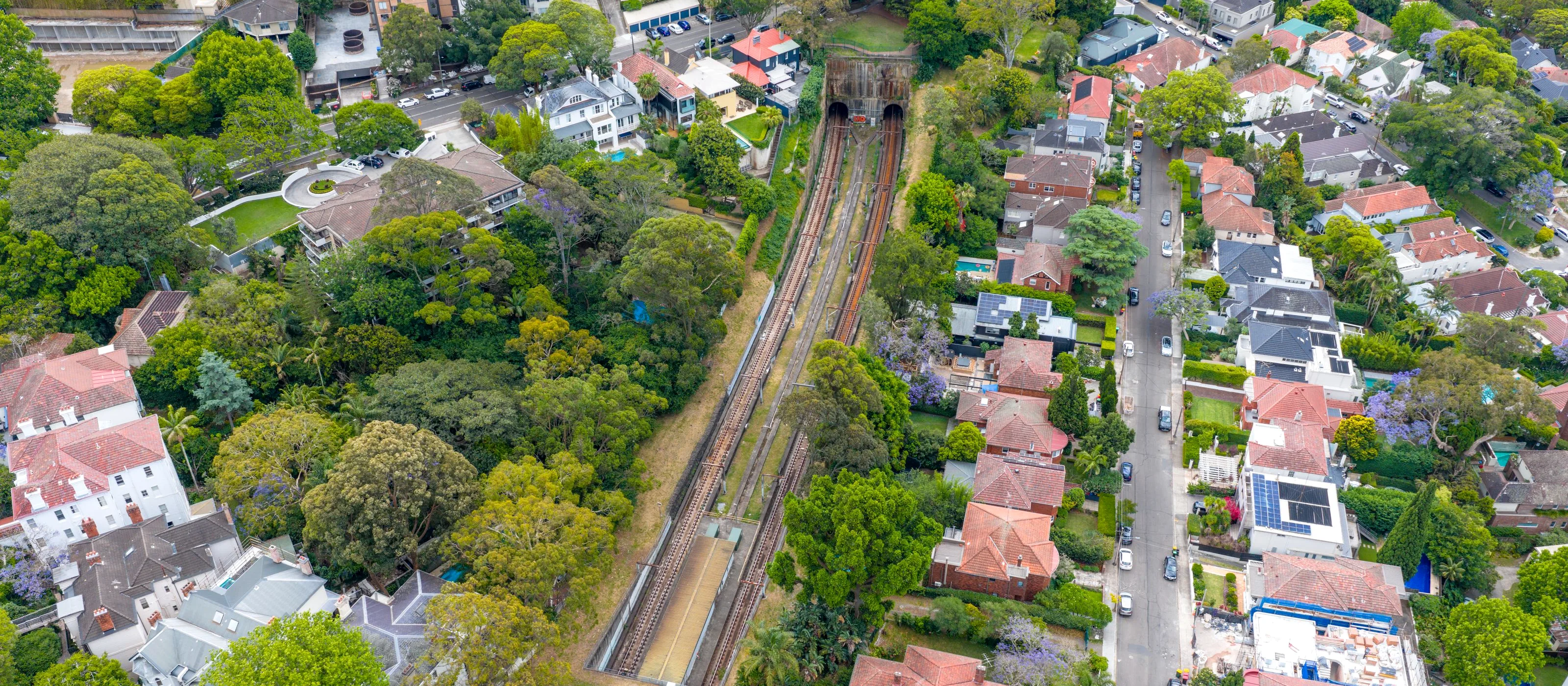 Aerial view of inner Sydney rooftops beside a railway line
