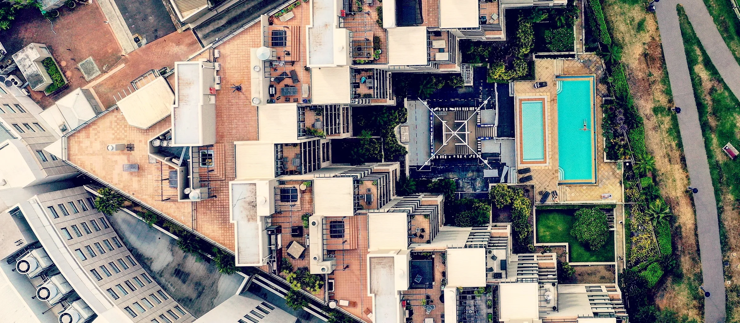 Aerial view of apartment rooftops with podium decks, plant platforms and pools