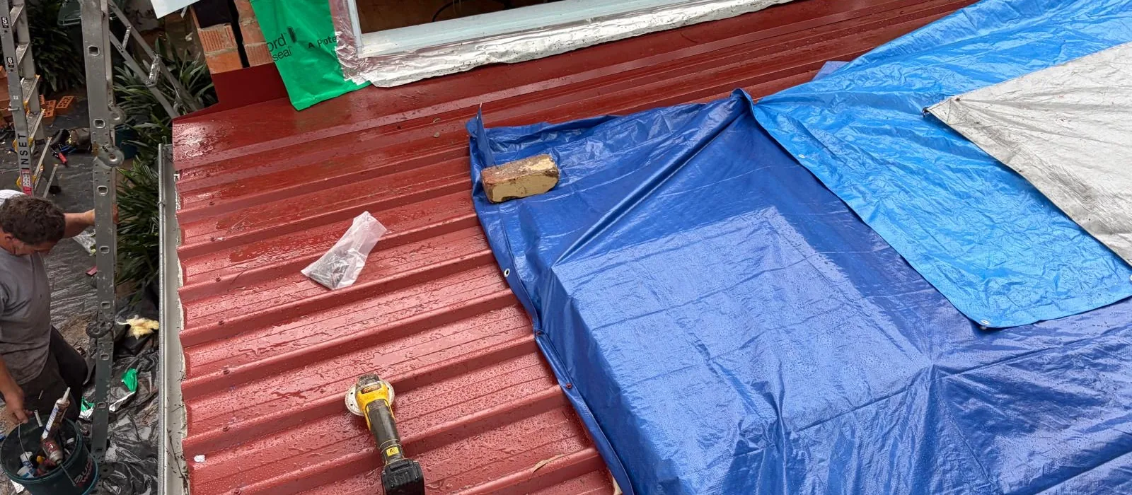 Metal roof part-way through replacement, tarpaulins and scaffold in place