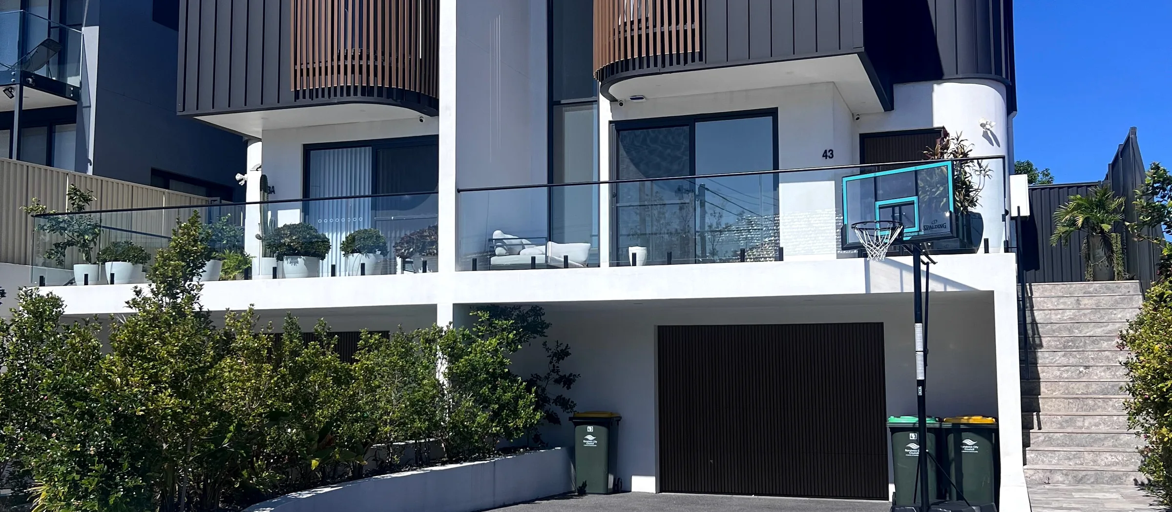 Large modern home with a complex roofline and dark cladding