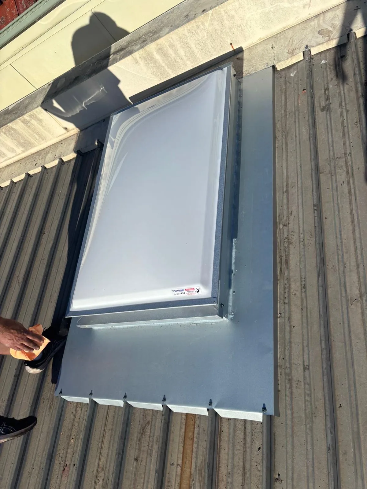 Skylight being installed into a corrugated metal roof